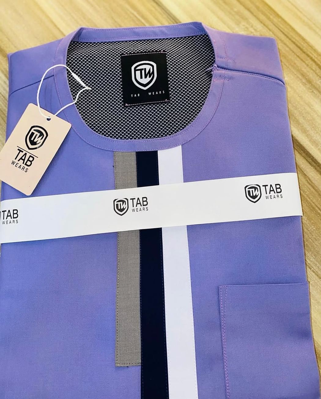A lilac TAB senator folded with a branded band and swing tag