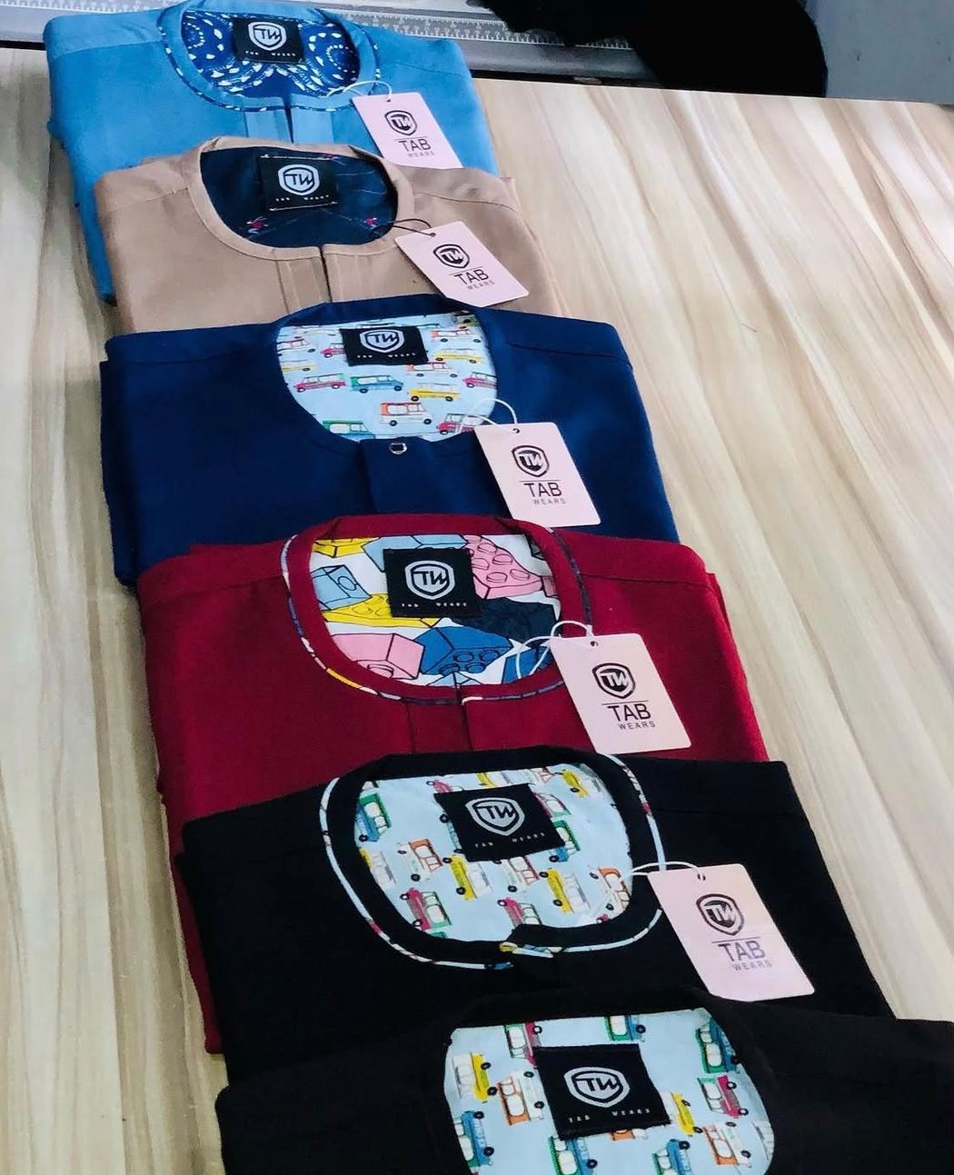 A row of folded TAB senators with branded tags and printed collar linings